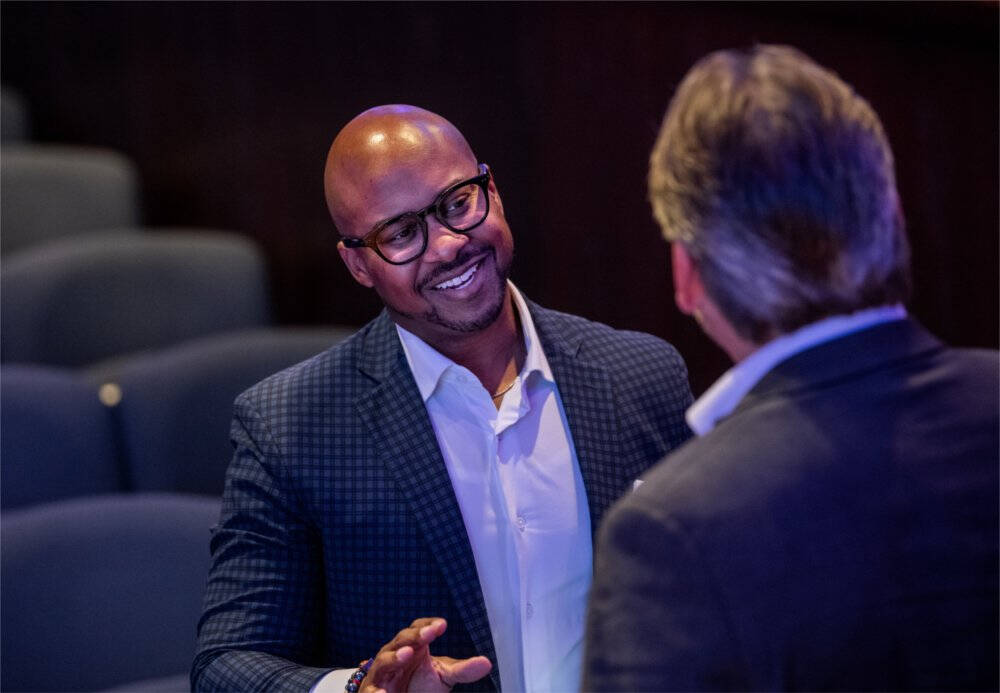 Rodney Robinson, with Dell Technologies, left, talks with a guest after speaking during "Tech Talks: AI & Human-Centered Design" at the DeVos Center's Loosemore Auditorium in Grand Rapids on September 18.